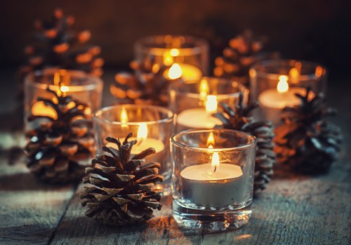 Christmas Christmas card with glowing small candle and fir cones